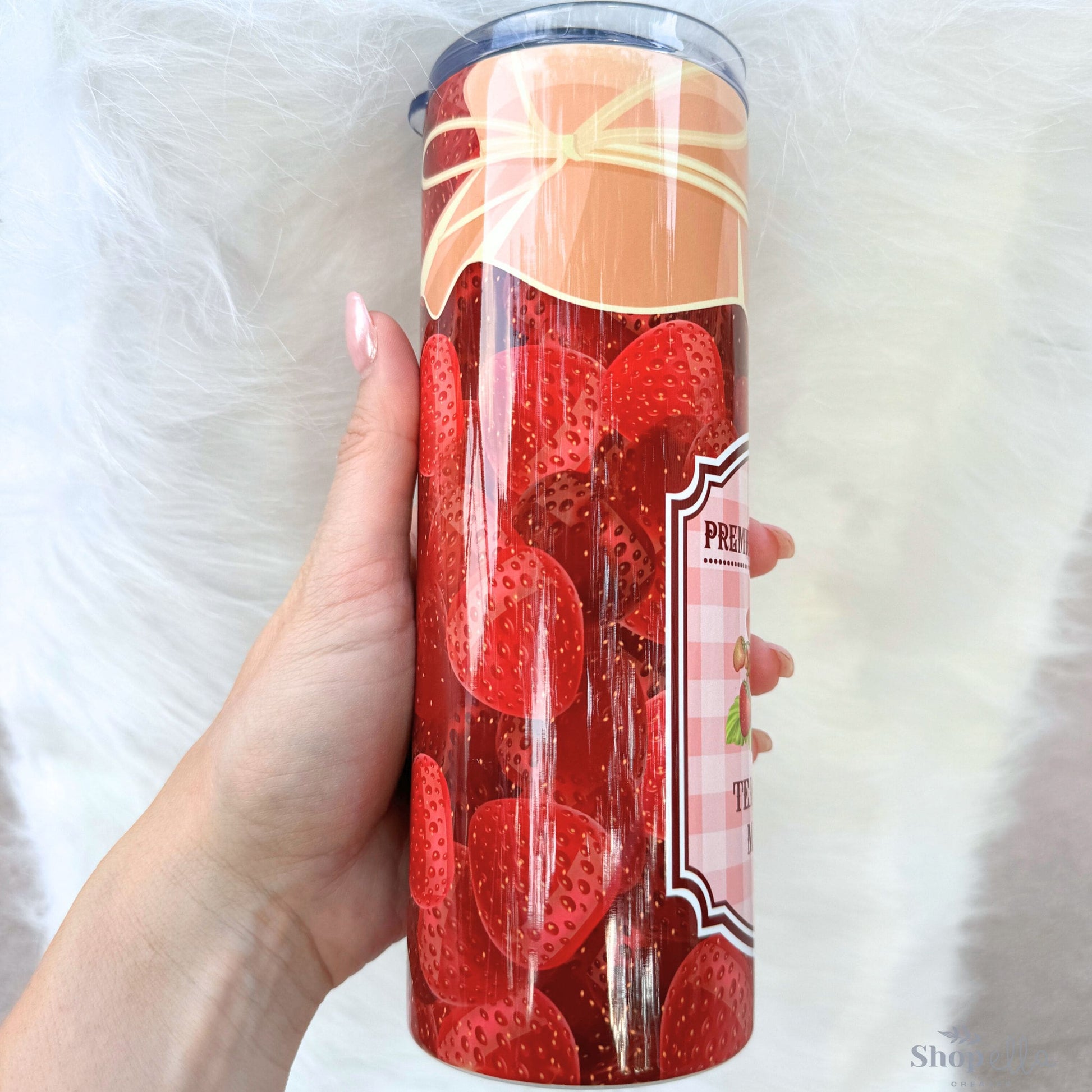 a person holding a red cup with strawberries on it