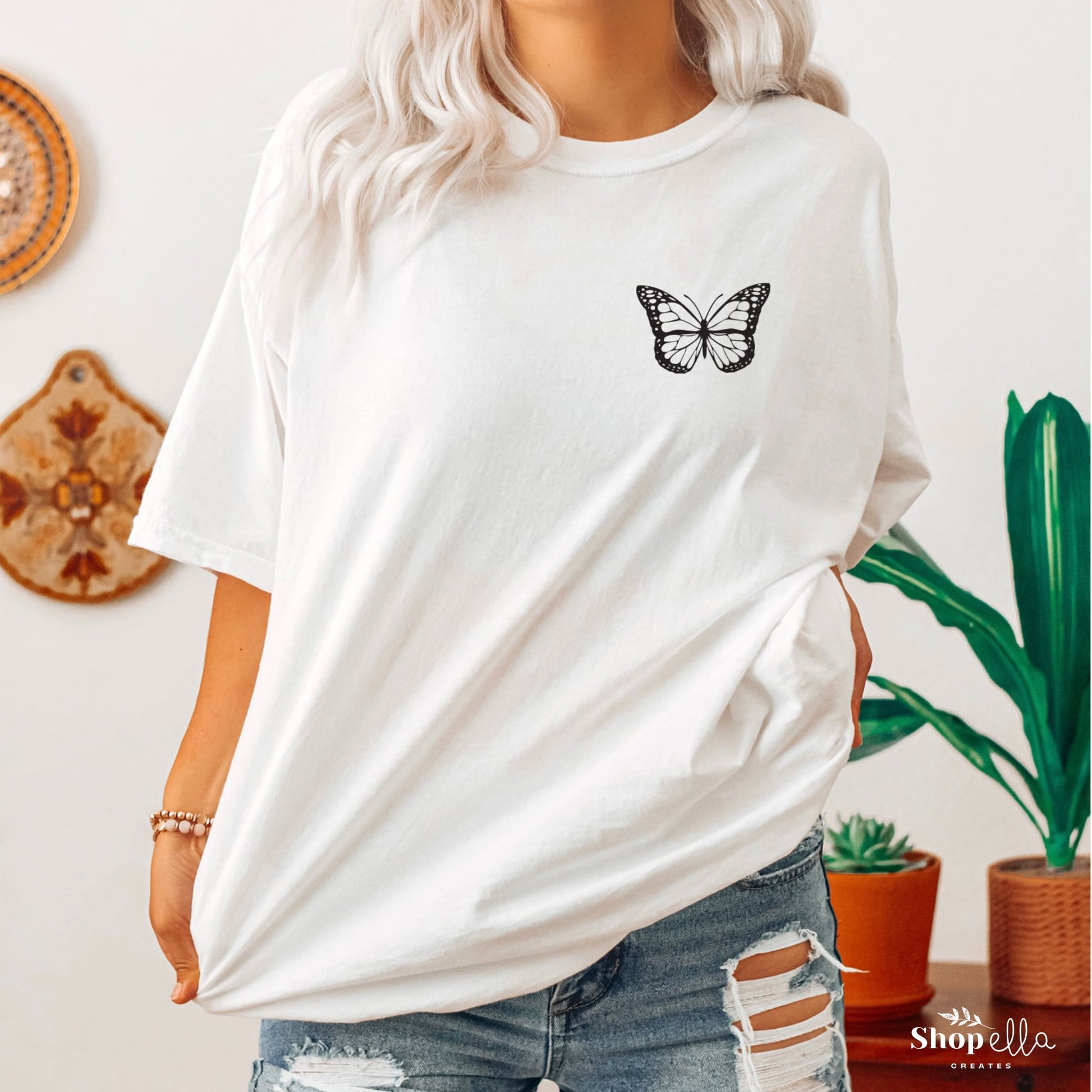 front of shirt has black butterfly in left front corner pocket on white short sleeve t-shirt