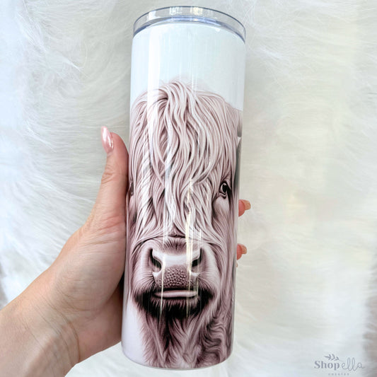 a hand holding a cup with a picture of a cow on it