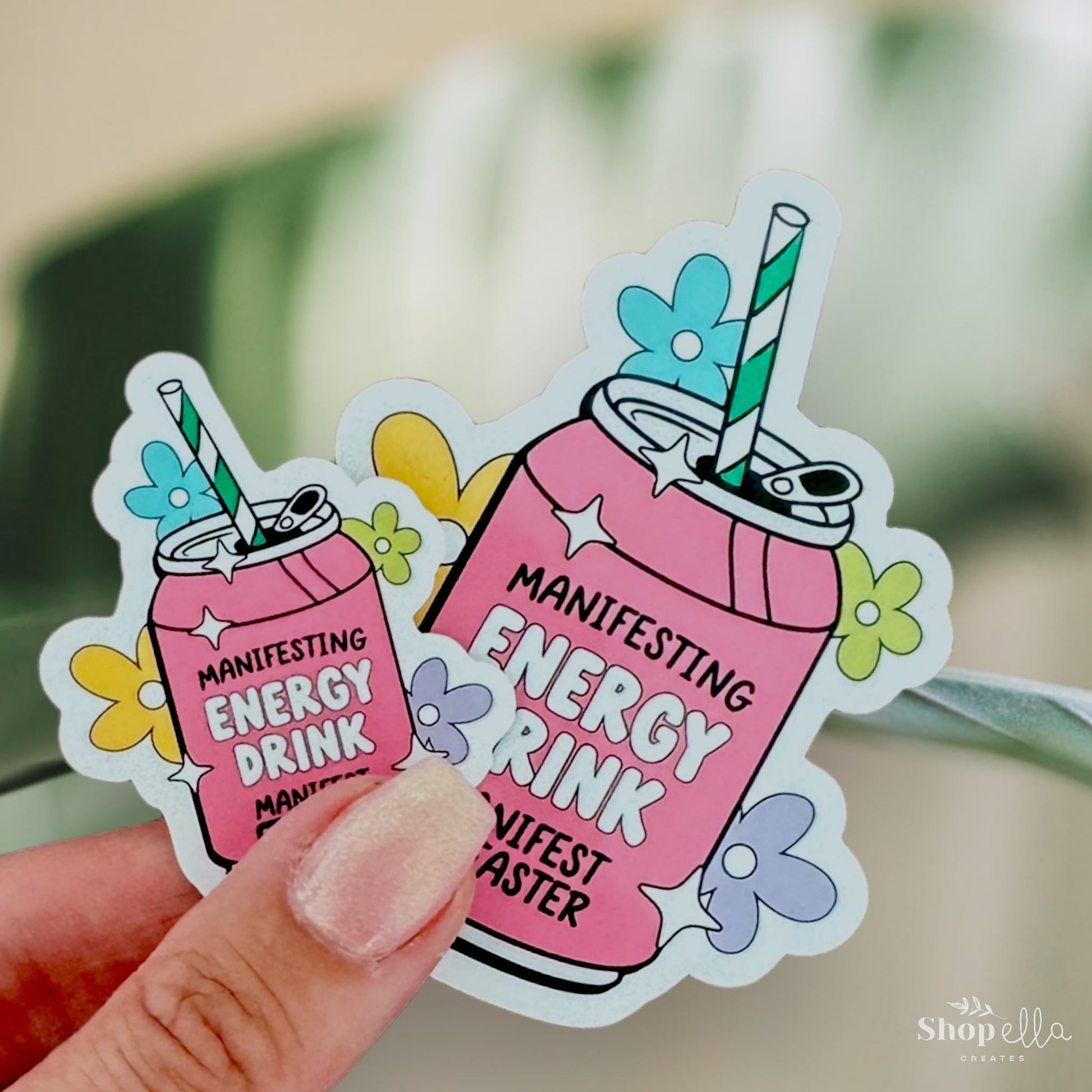 a hand holding a sticker of a pink drink