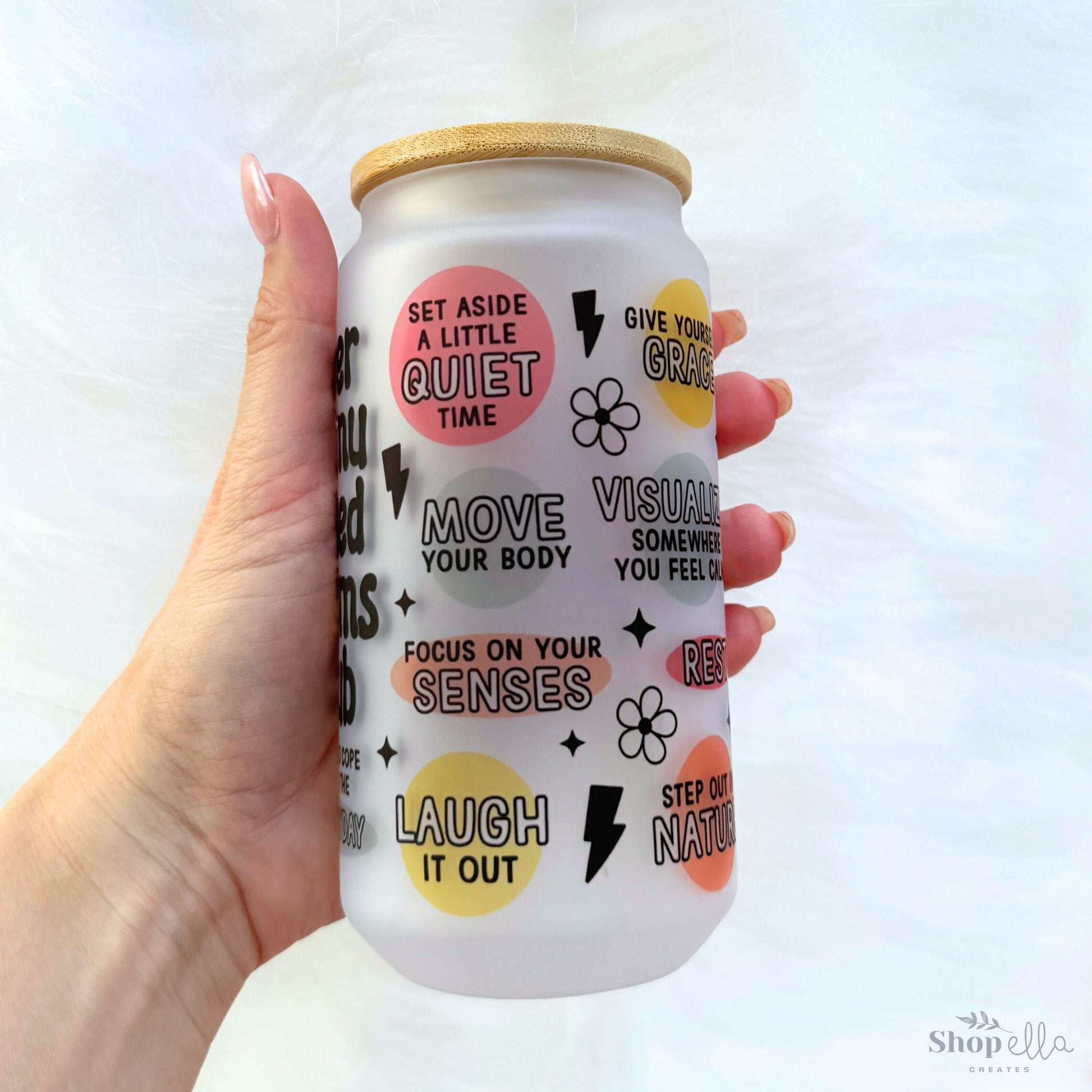 a hand holding a can of soda with stickers on it