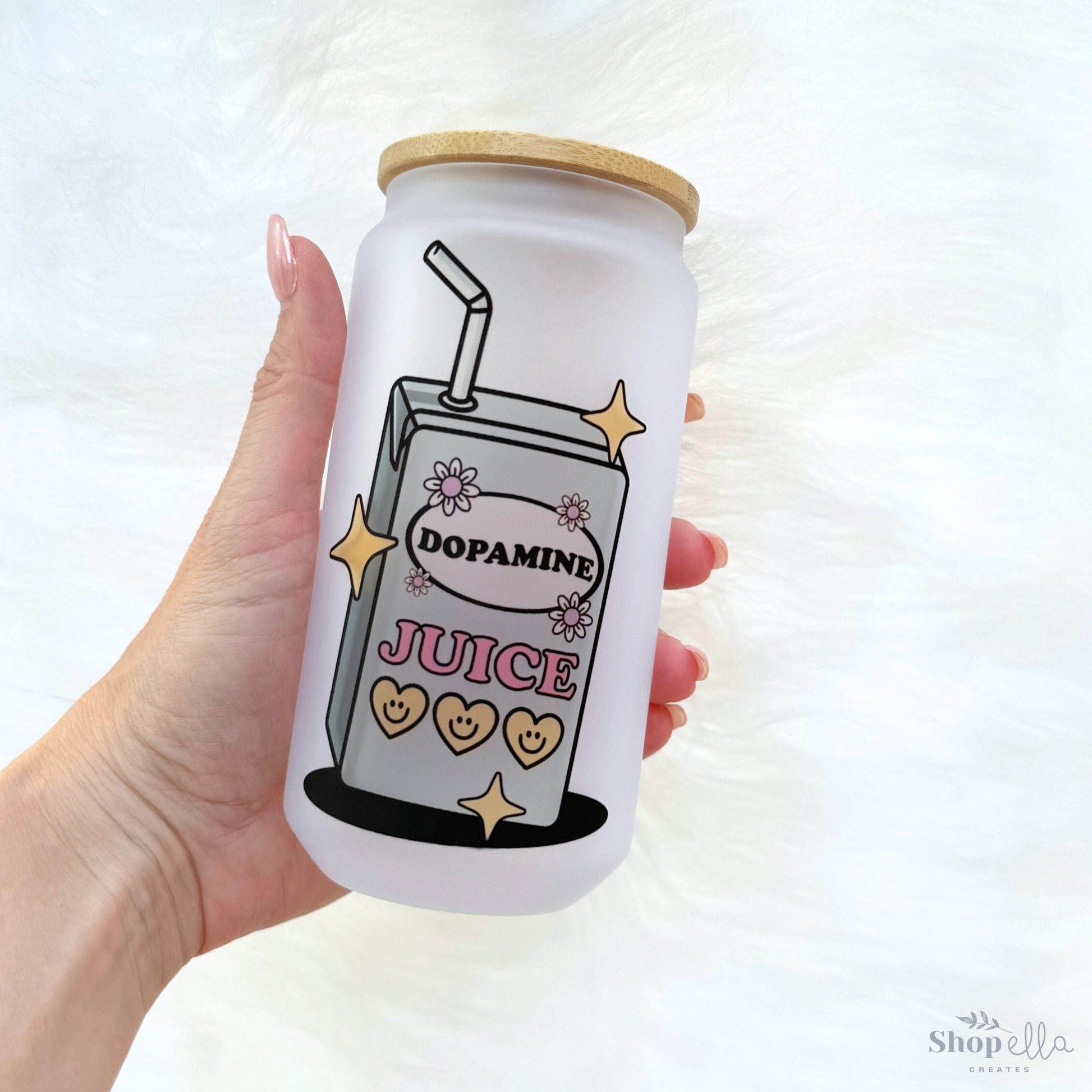 a hand holding a can of juice with a straw in it