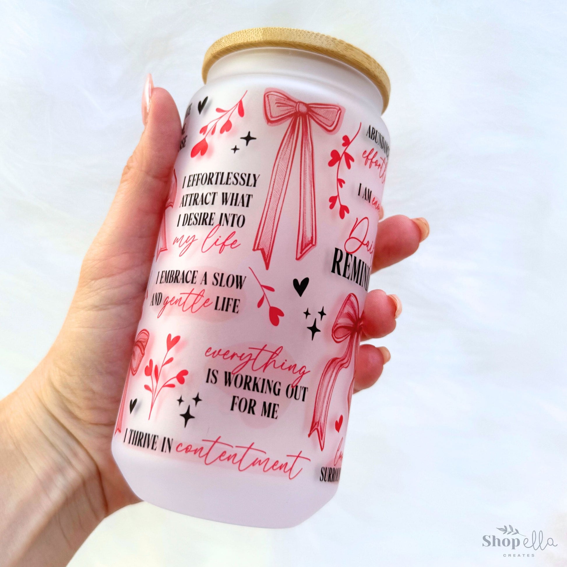 a hand holding a can of coffee with a red bow on it