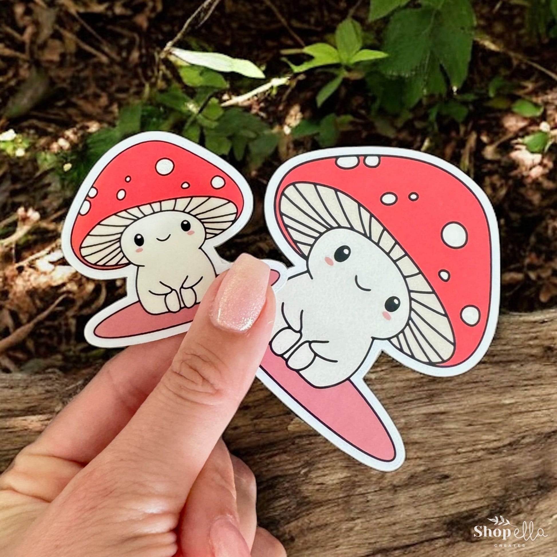 a hand holding a sticker of two mushrooms