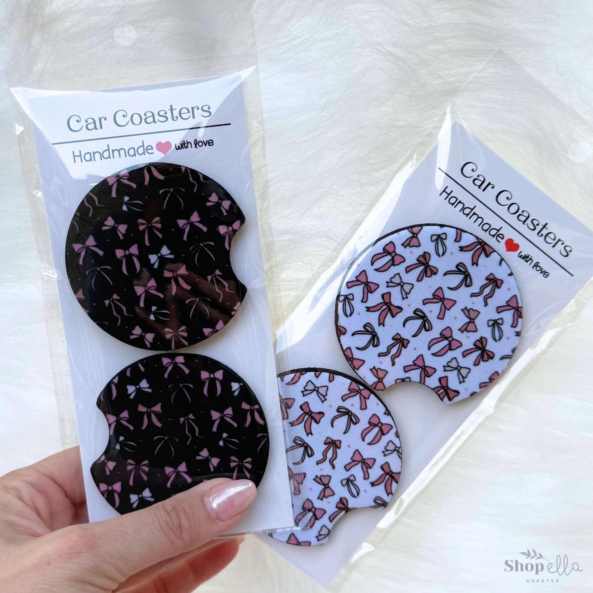 2 packages of car coasters with pink and beige bows on white background and black background