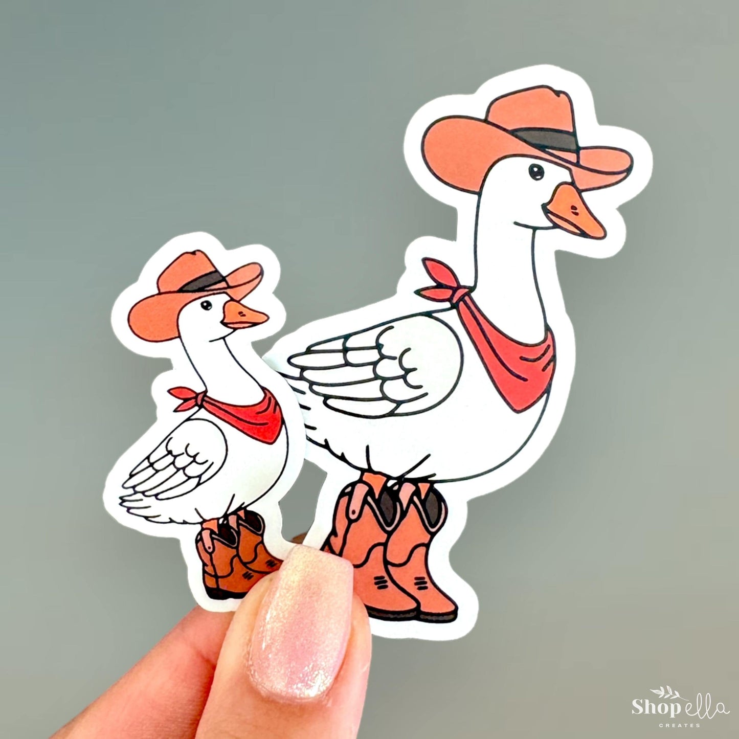 a hand holding a sticker of a duck and a duckling