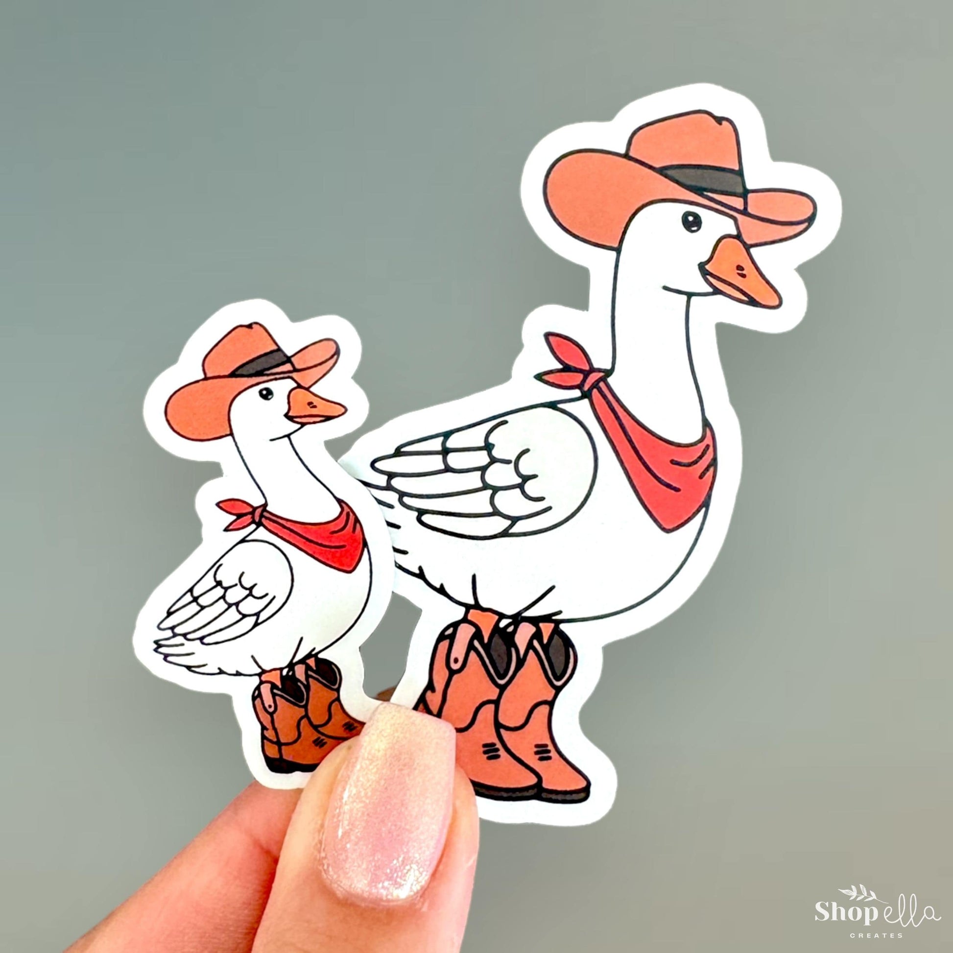 a hand holding a sticker of a duck and a duckling