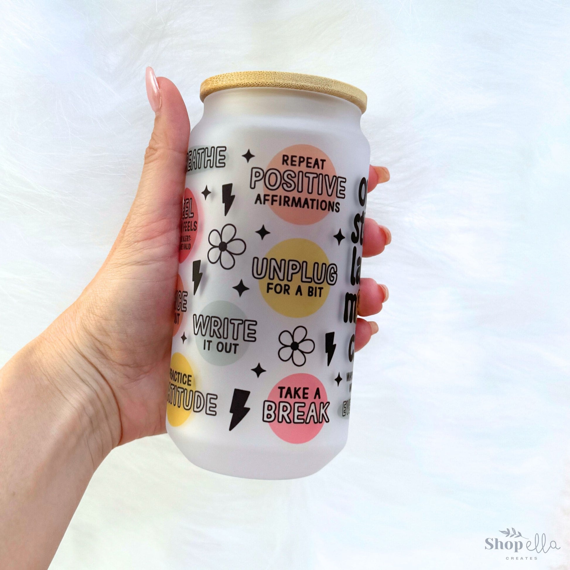 a hand holding a can of drink with a pattern on it