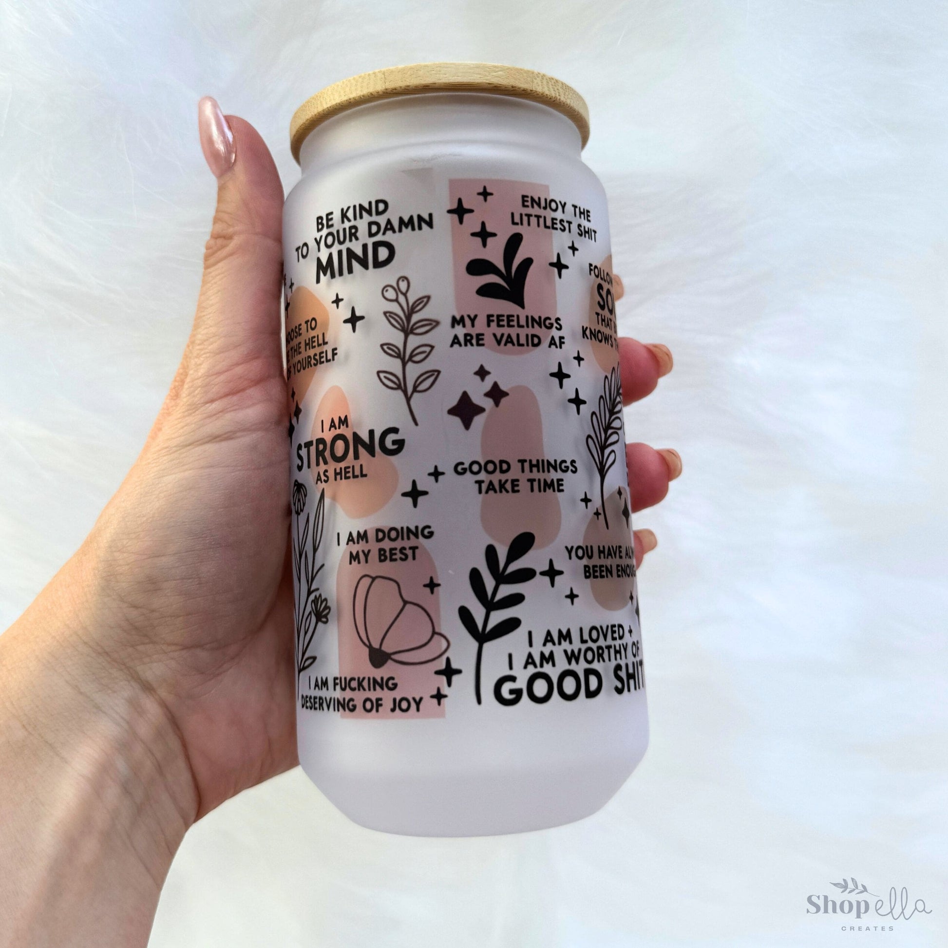 a hand holding a white can with stickers on it