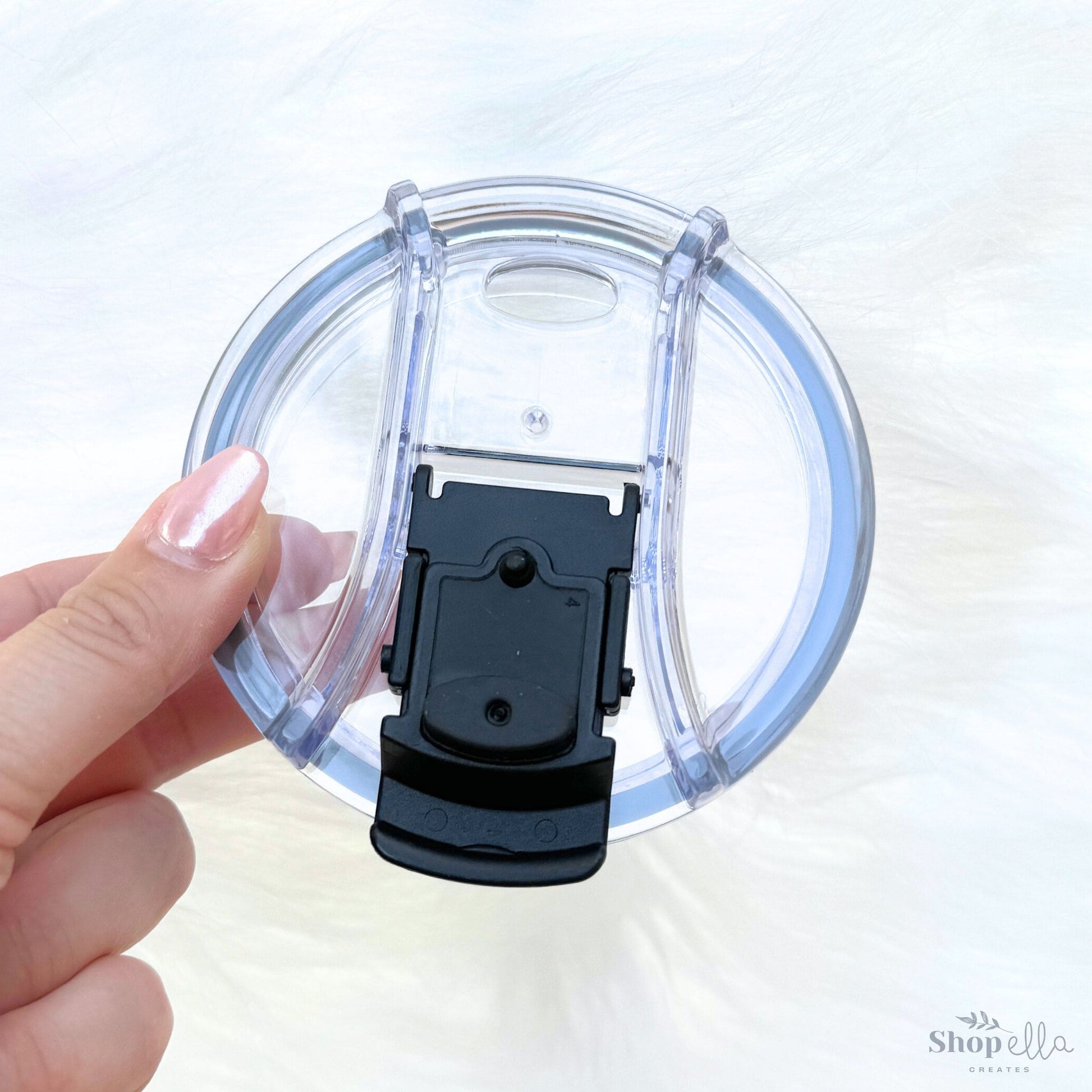 a hand is holding a plastic object in the shape of a clock