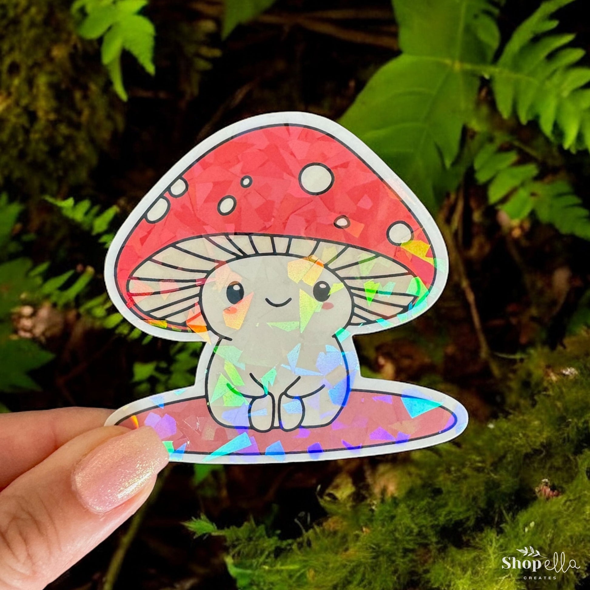 a hand holding a sticker with a picture of a mushroom on it