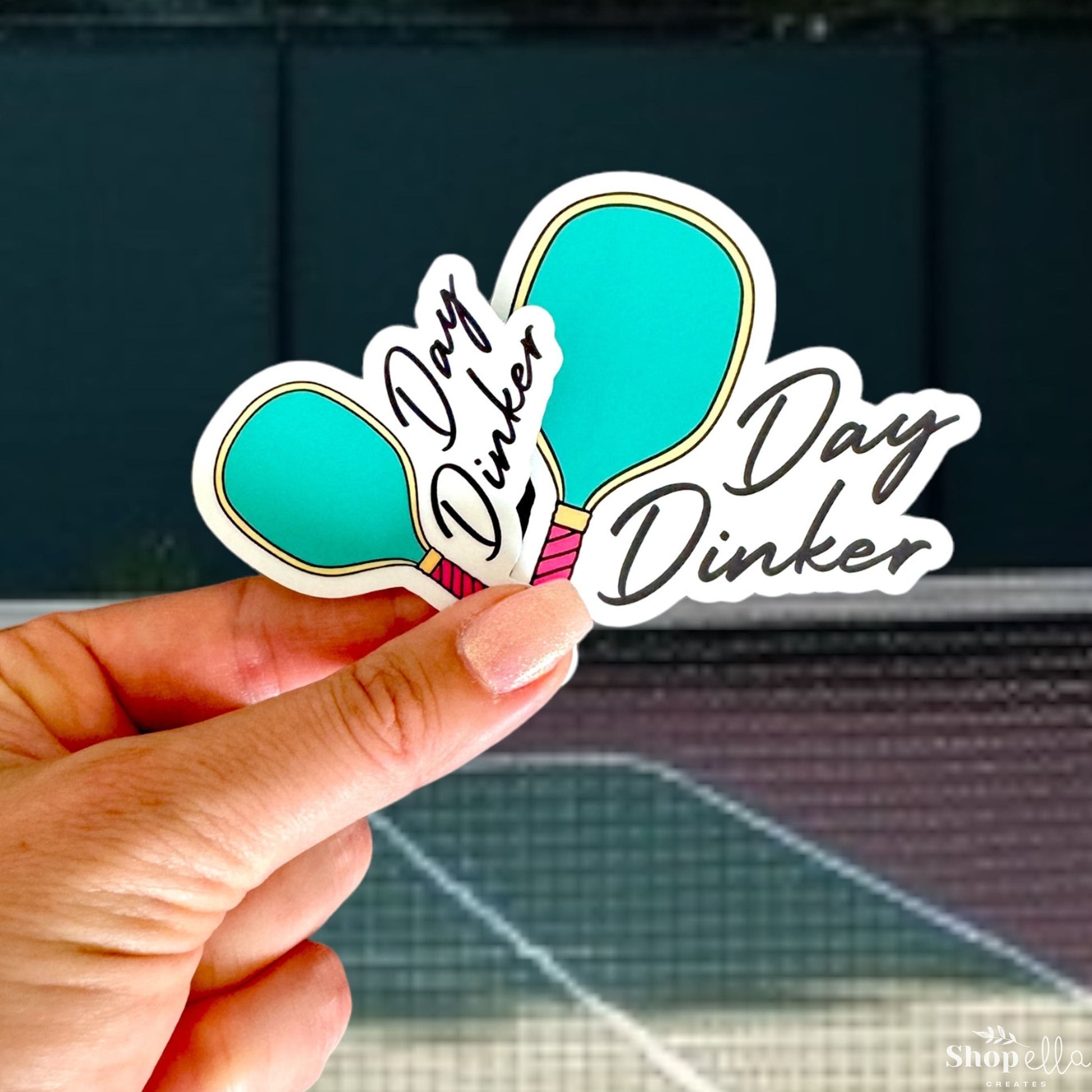 a hand holding a sticker with a picture of a flower