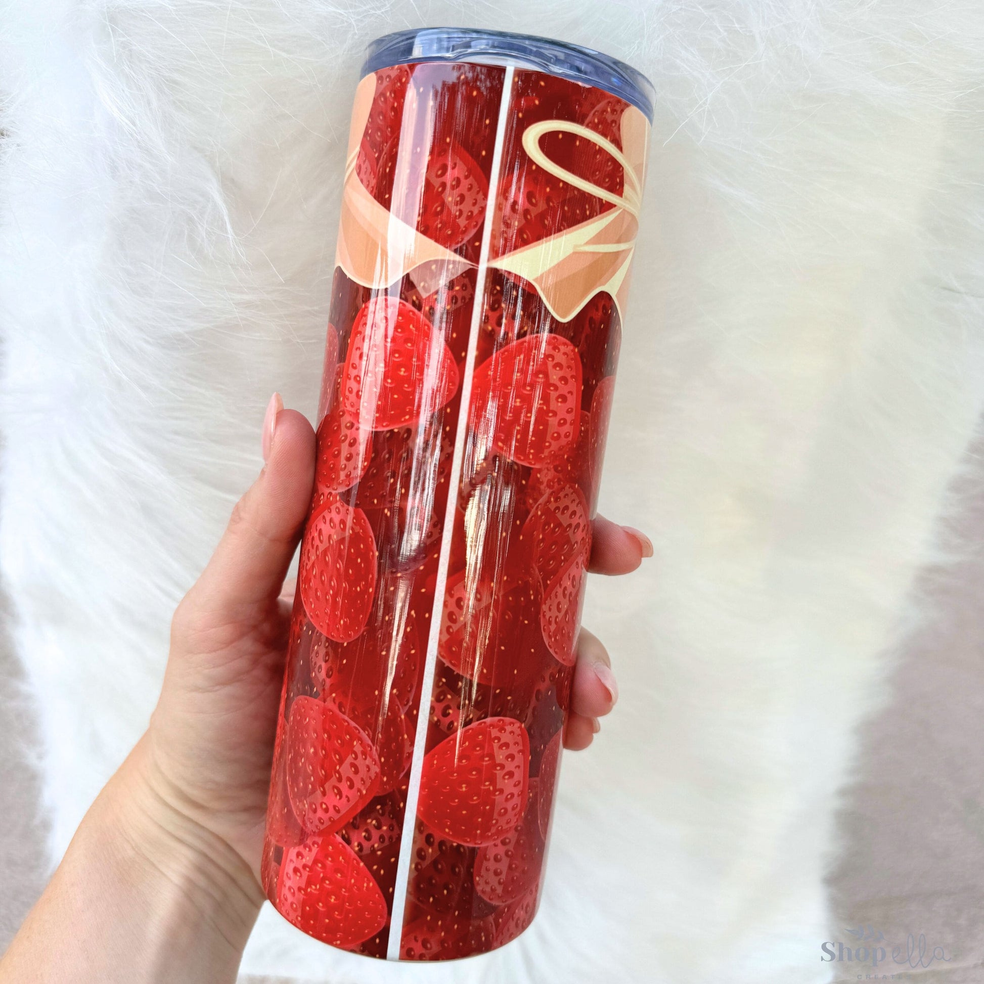 a person holding a red cup with strawberries in it